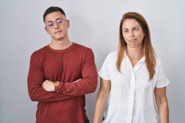 Mother and son standing together over isolated background looking sleepy and tired, exhausted for fatigue and hangover, lazy eyes in the morning. 