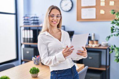 Ofiste belge okuyan genç bir iş kadını.