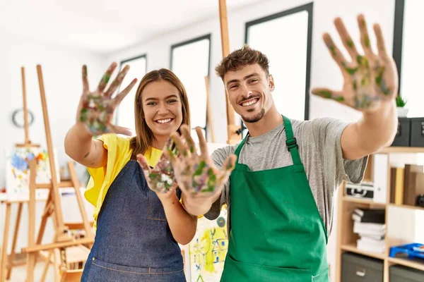 Young Hispanic Artist Couple Smiling Happy Showing Painted Palm Hands — Fotografia de Stock