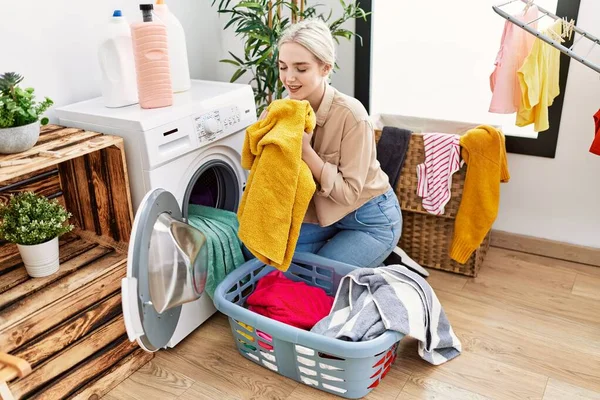 Joven Mujer Caucásica Sonriendo Confiado Oliendo Ropa Sala Lavandería —  Fotos de Stock