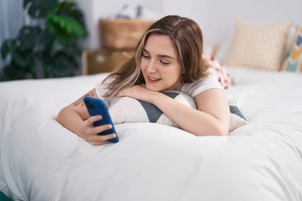 Νεαρή Γυναίκα Που Χρησιμοποιεί Smartphone Ξαπλωμένη Στον Καναπέ Στο Υπνοδωμάτιο — Φωτογραφία Αρχείου