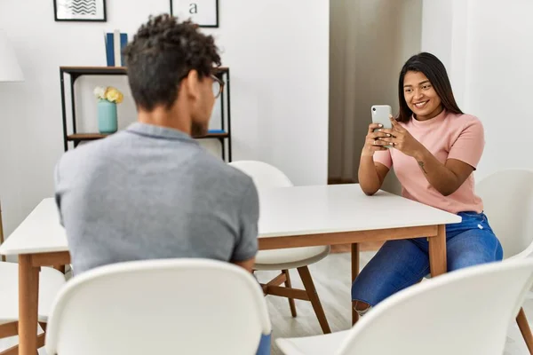 Young Latin Woman Making Man Picture Using Smartphone Home — Stok fotoğraf