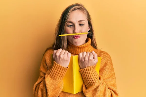 Joven Mujer Rubia Sosteniendo Libro Lápiz Sobre Boca Como Bigote —  Fotos de Stock