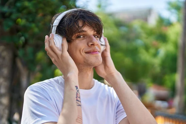 Νεαρός Ξανθός Άντρας Χαμογελά Σίγουρος Ακούγοντας Μουσική Στο Πάρκο — Φωτογραφία Αρχείου