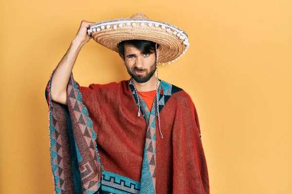 Jovem Hispânico Segurando Chapéu Mexicano Confundir Perguntar Sobre Pergunta Incerto — Fotografia de Stock