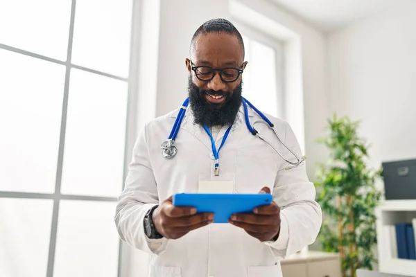 Young African American Man Wearing Doctor Uniform Using Touchpad Clinic — стокове фото