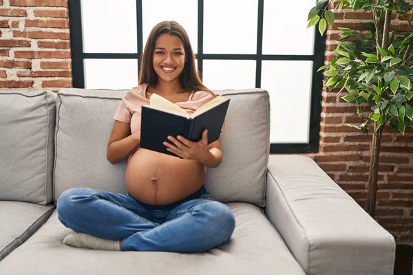 Young Latin Woman Pregnant Touching Belly Reading Book Home — 스톡 사진