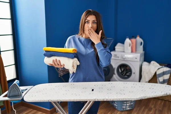 Ung Brunett Kvinna Håller Vikta Tvätt Efter Strykning Täcker Munnen — Stockfoto