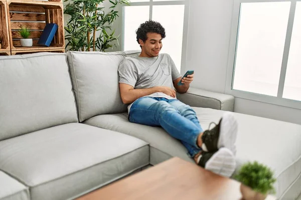 Mladý Hispánec Pomocí Smartphone Sedí Pohovce Doma — Stock fotografie