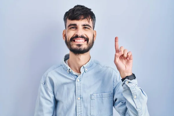 Young Hispanic Man Beard Standing Blue Background Showing Pointing Finger — Stok fotoğraf