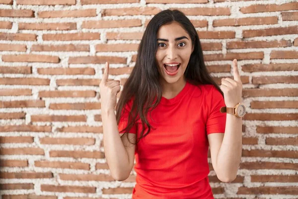 Tuğla Duvarın Üzerinde Duran Genç Kız Şaşırmış Şaşırmış Parmaklarıyla Işaret — Stok fotoğraf
