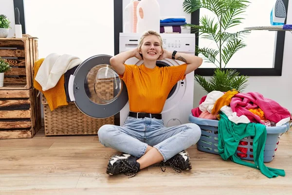 Çamaşır Makinesinin Yanında Oturan Genç Sarışın Kadın Rahatlıyor Esniyor Kolları — Stok fotoğraf