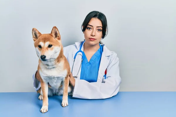 Schöne Hispanische Tierärztin Überprüft Hund Gesundheit Denkhaltung Und Nüchternen Ausdruck — Stockfoto