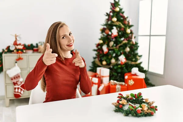 Caucasian Young Blonde Woman Sitting Table Christmas Tree Pointing Fingers — Stockfoto