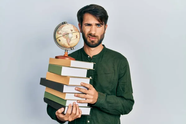 Joven Hombre Hispano Sosteniendo Libros Bola Del Mundo Sin Pistas — Foto de Stock