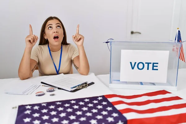 Young Brunette Woman Political Election Sitting Ballot Amazed Surprised Looking — Stock Photo, Image