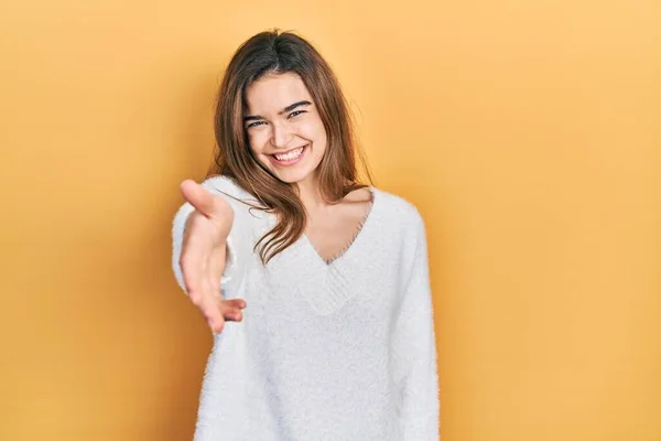 Młoda Kaukaska Dziewczyna Luźnych Ubraniach Uśmiechnięta Przyjazna Oferująca Uścisk Dłoni — Zdjęcie stockowe