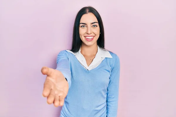 美丽的女人 蓝眼睛站在粉红的背景上 微笑友好地握手致意和欢迎 成功的商业 — 图库照片