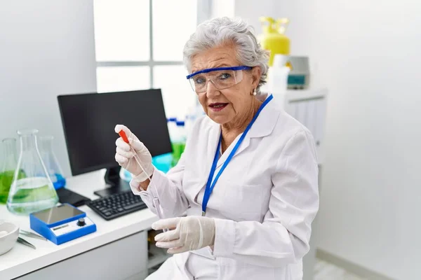 Starsza Siwowłosa Kobieta Mundurze Naukowca Używająca Pipety Probówki Laboratorium — Zdjęcie stockowe