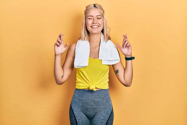 Beautiful Blonde Sports Woman Wearing Workout Outfit Gesturing Finger Crossed — Stockfoto