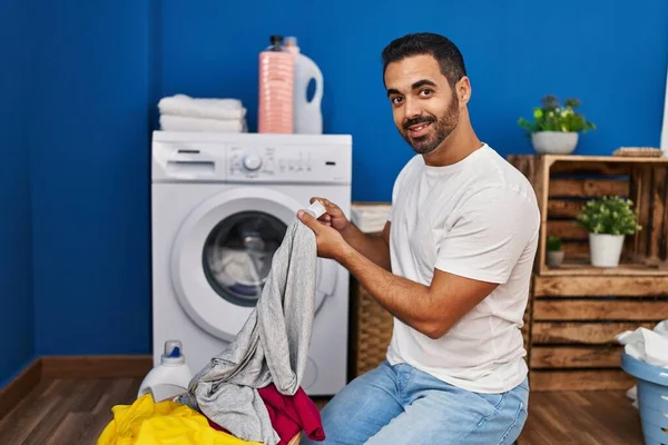 Jonge Spaanse Man Wassen Kleding Zoek Shirt Label Wasruimte — Stockfoto
