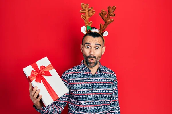 Ung Latinamerikansk Man Bär Rådjur Jul Hatt Hålla Gåva Rädd — Stockfoto