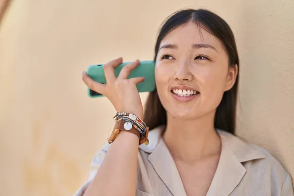 Китаянка Улыбается Уверенно Слушая Аудио Сообщение Смартфона Белом Изолированном Фоне — стоковое фото