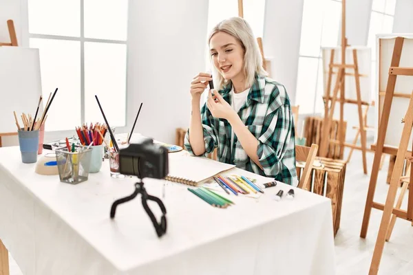 若い芸術家の学生の女の子幸せな絵を粉砕 アートスタジオでデスクレコーディング アート クラスに座って — ストック写真