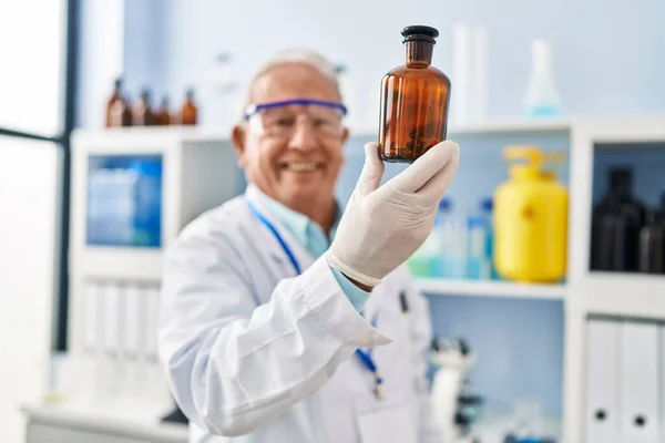 Starszy Mężczyzna Mundurze Naukowca Trzymający Butelkę Laboratorium — Zdjęcie stockowe