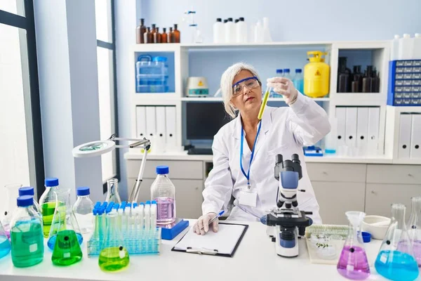 研究室で科学者の均一な保持試験管を身に着けている中年女性 — ストック写真