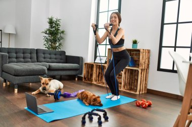 Evde elastik bant kullanan kendine güvenen İspanyol bir kadın.