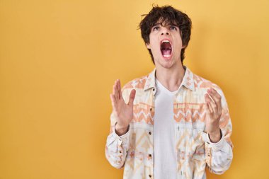 Yazlık tişört giyen genç adam deli gibi bağırıyor ve agresif bir ifade ve kollarla bağırıyor. hüsran kavramı. 