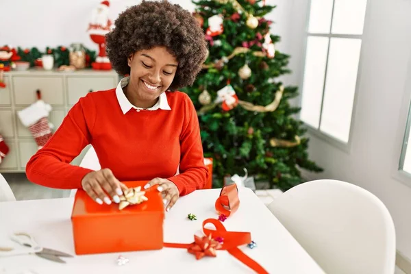Joven Mujer Afroamericana Sonriendo Confiado Embalaje Regalo Navidad Casa —  Fotos de Stock