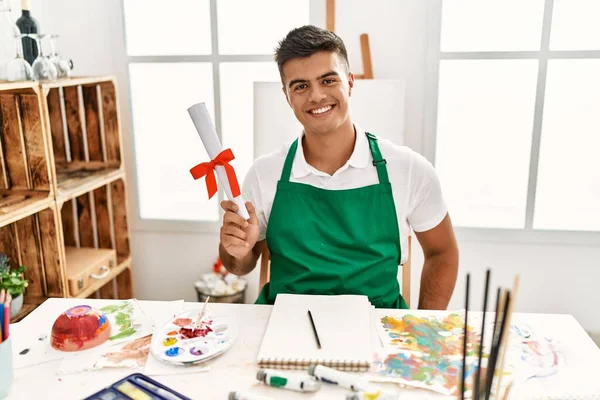 Young Hispanic Man Smiling Confident Holding Diploma Art Studio — Zdjęcie stockowe
