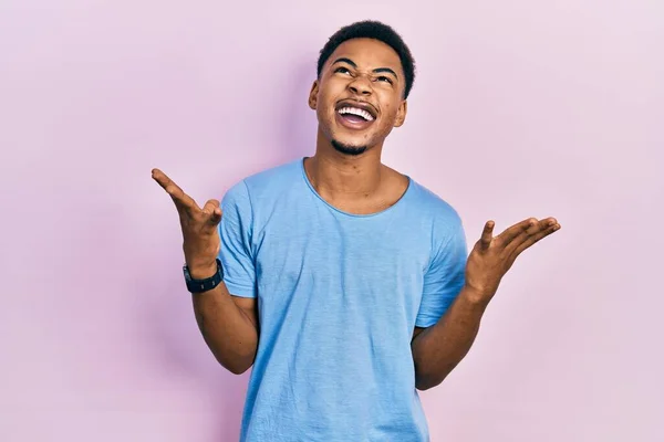 カジュアルなブルーのTシャツを着た若いアフリカ系アメリカ人の男性は 狂気と怒りの叫びと積極的な表現と腕を上げて叫んでいた フラストレーションコンセプト — ストック写真