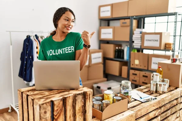 Beautiful Hispanic Woman Wearing Volunteer Shirt Working Laptop Pointing Thumb — Stock Photo, Image