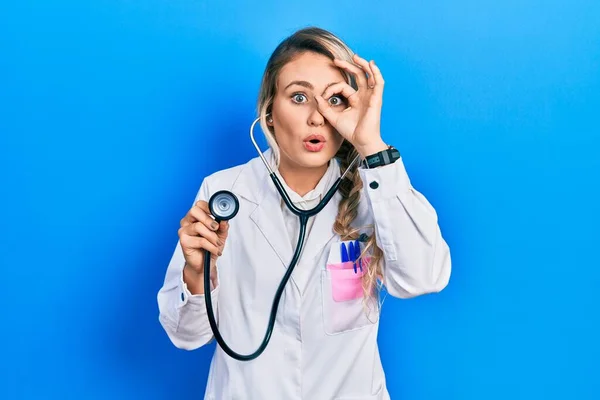 Beautiful Young Blonde Doctor Woman Holding Stethoscope Doing Gesture Shocked — Stok fotoğraf
