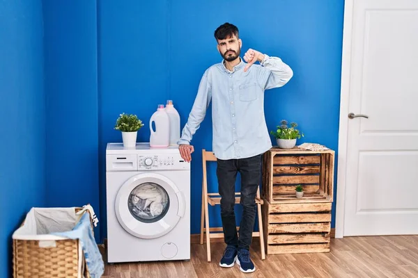 Young Hispanic Man Beard Doing Laundry Standing Laundry Room Angry — Fotografia de Stock