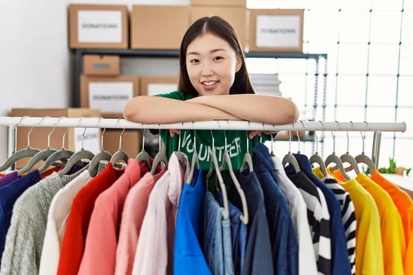 寄付された服を着て微笑む若いアジア人女性が立つ — ストック写真