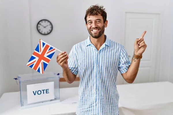 英俊潇洒的年轻人在选战中举着英国国旗 满面春风 手指手画脚 — 图库照片