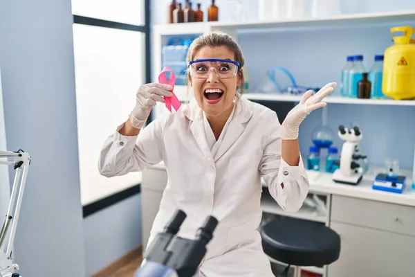 Young Woman Working Scientist Laboratory Holding Pink Ribbon Celebrating Victory — Foto Stock