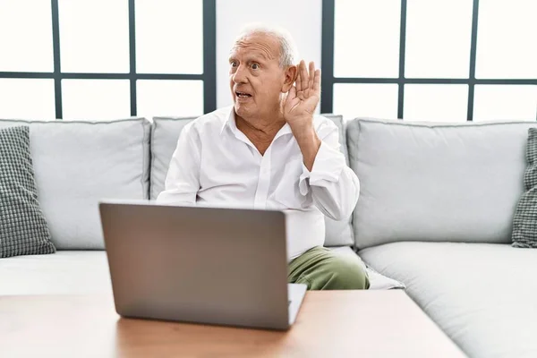 Senior Man Using Laptop Home Sitting Sofa Smiling Hand Ear — Foto de Stock