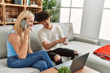 Aile ekonomisini kontrol eden genç bir çift akıllı telefon kullanarak ev ekonomisine danışmanlık yapıyor..