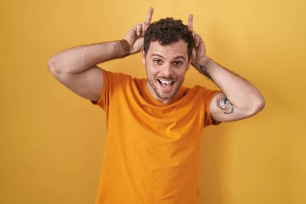 Jovem Hispânico Homem Sobre Fundo Amarelo Posando Engraçado Louco Com — Fotografia de Stock