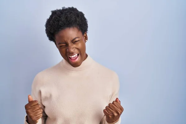 Afroameričanka Stojící Nad Modrým Pozadím Velmi Šťastná Nadšená Dělá Vítězný — Stock fotografie