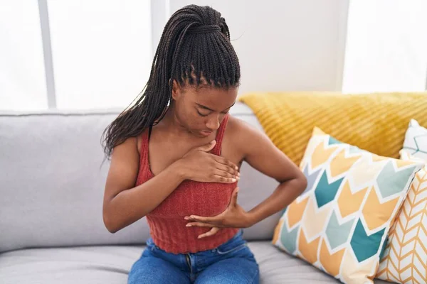 Afrikansk Amerikansk Kvinna Undersöker Bröst Med Handen Sitter Soffan Hemma — Stockfoto