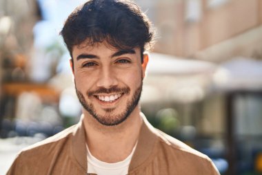 Sokakta kendinden emin gülümseyen İspanyol genç adam.