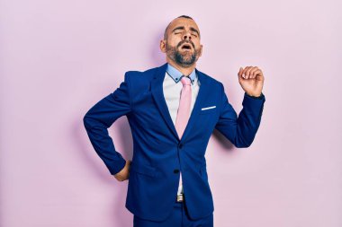 Genç İspanyol adam iş elbisesi ve kravat takıyor, yorgun ve rahat, uykulu ve sabahın erken saatleri için esniyor. 