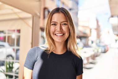 Sokakta kendine gülen genç İspanyol kadın.