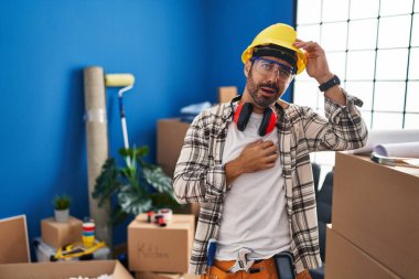 Sakallı, evde tamirat yapan, hastalık, ateş, grip ve virüs için alnına dokunan genç İspanyol bir adam. 